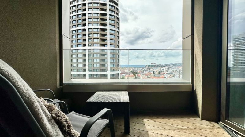 A view from the balcony of a two-room apartment of the panorama of Bratislava and a modern skyscraper.