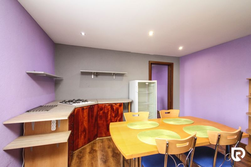 A kitchen in a family house with a wooden decor floor, table, and chairs.