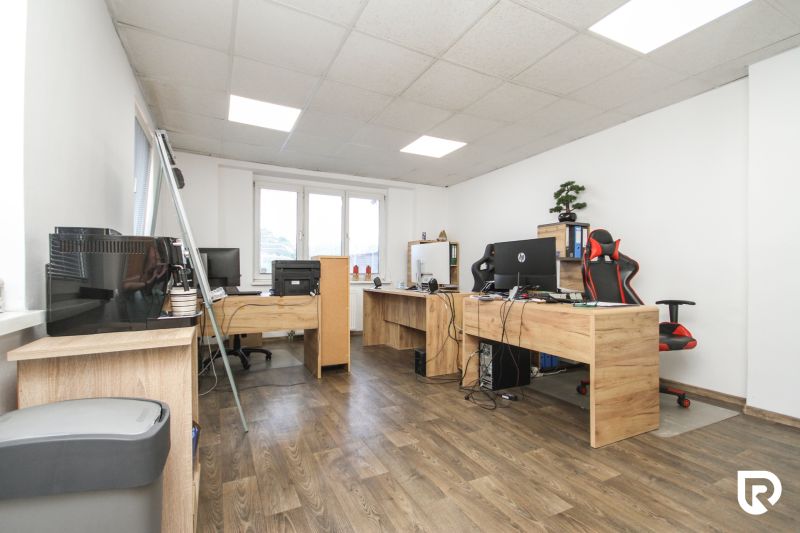 An office with wooden floor decor and work desks in a family house.