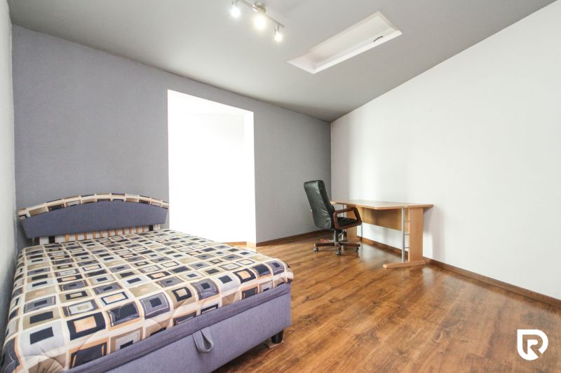 Bedroom with a bed, table, and floor with a wooden decor.