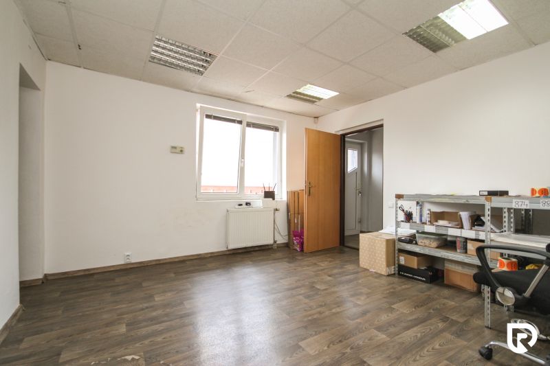 A room in a family house with a wooden decor floor, a shelf, and a radiator.
