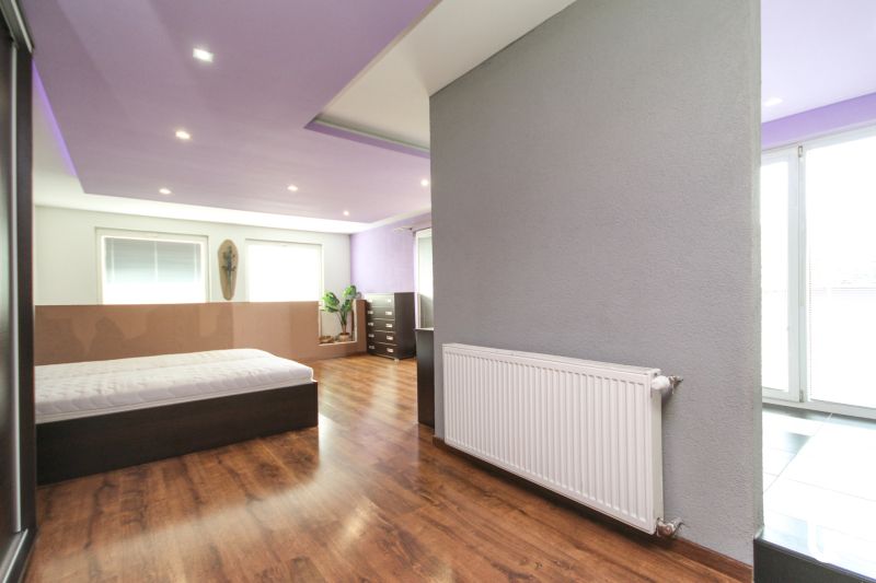 A bedroom in a family house with a purple ceiling and a wooden decor floor.