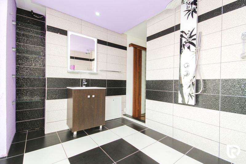 Bathroom in a family house with black and white tiles and minimalist furniture.