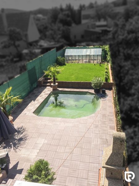 The garden of a family house on Kubranská Street in Trenčín with a swimming pool and a greenhouse.