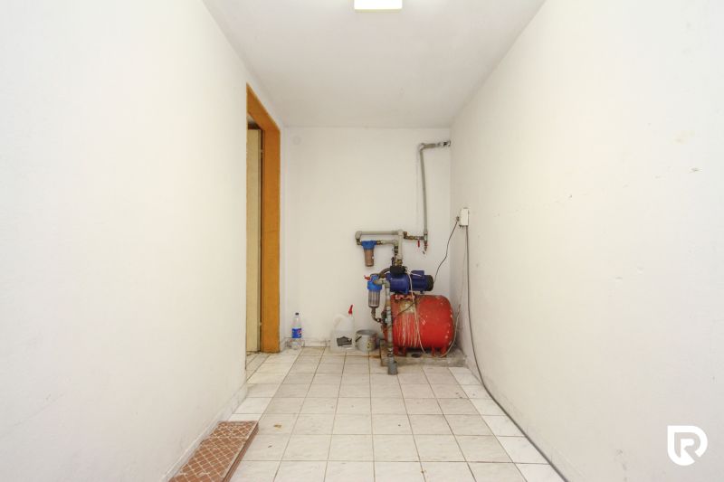 A technical room with white walls and equipment installation in a family house.