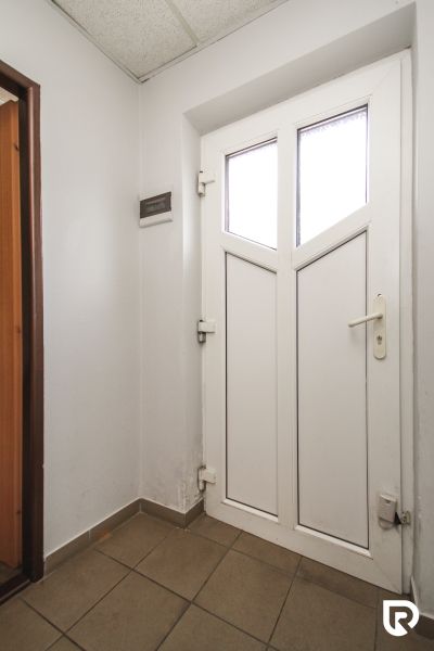 White entrance door in the interior with tiles in a family house.