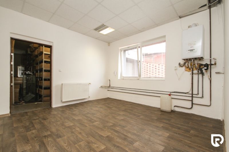 A white interior of a family house with a boiler and a wooden decor floor.