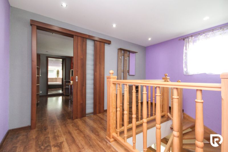 Staircase with railing and sliding doors, floor with wood decor, family house.