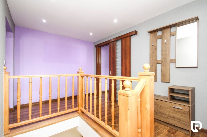 A hallway in a family house with wooden railing and flooring with a wooden decor.