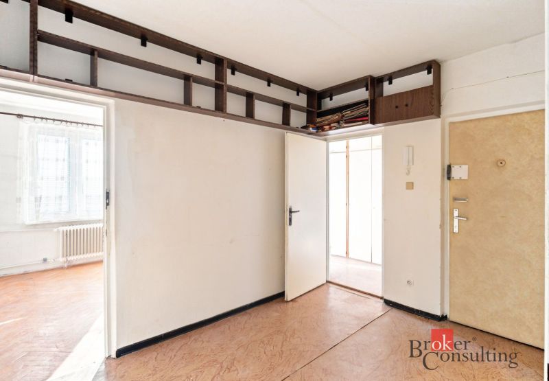 In the 2-room apartment, there is a bright room with built-in cabinets and a floor with a wooden decor.