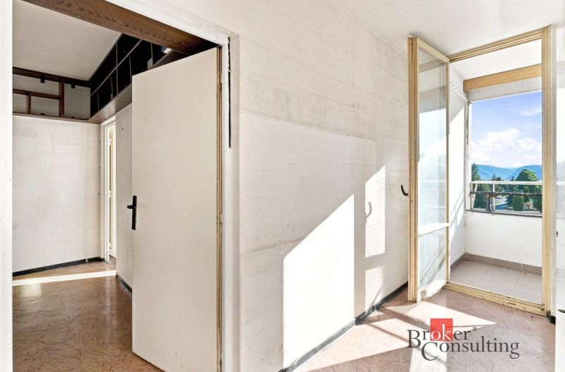 Hallway in a 2-room apartment with access to the balcony, with a wooden decor floor.