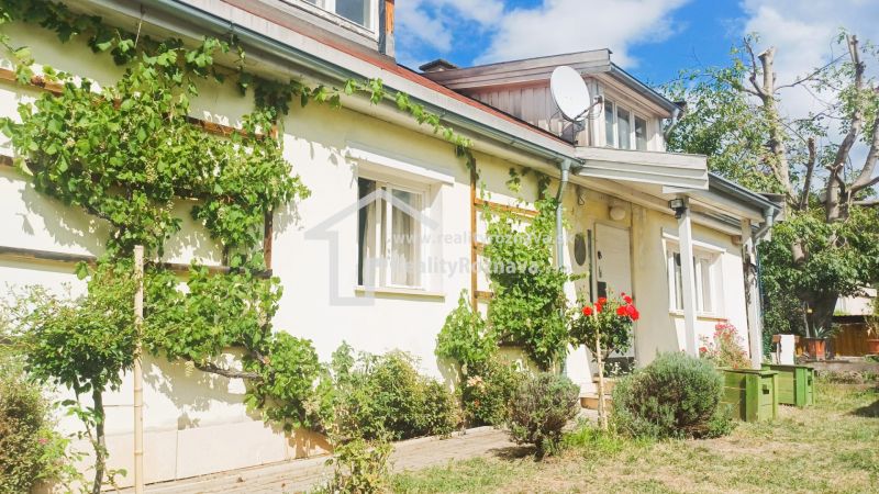 A family house in Rožňava with climbing plants and a two-story roof.