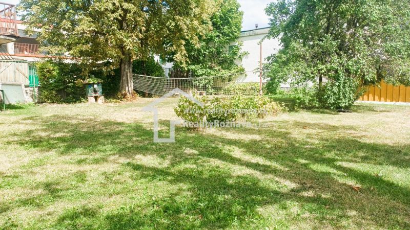 The garden of a family house in Rožňava, a grassy area with a volleyball net and trees.