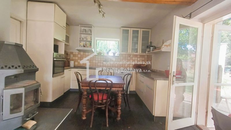 A family house kitchen with a dining table, fireplace, and wooden decor flooring.