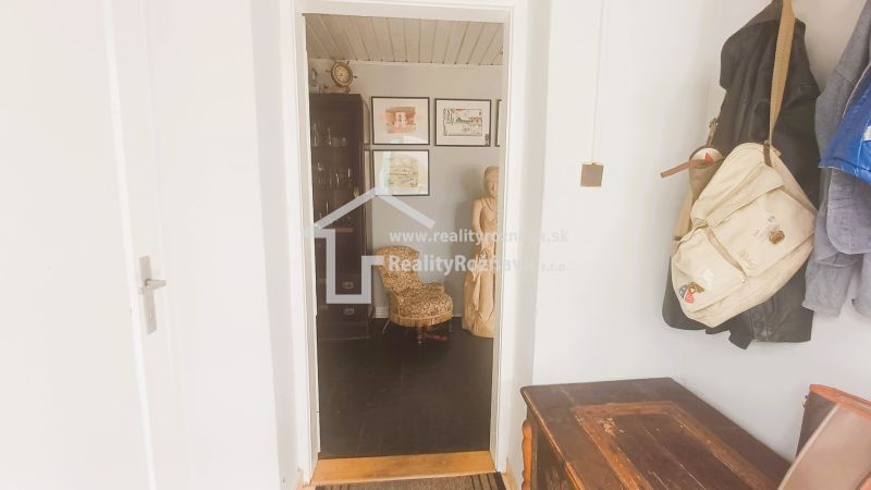 A family house with a hallway, an art sculpture, and coat racks in the interior.