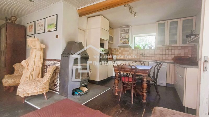 Interior of a family house with a kitchen, wooden sculpture, and fireplace, floor with wooden decor.