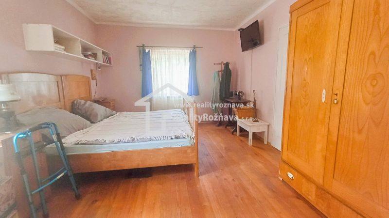 A bedroom in a family house with classic furniture and a wooden decor floor.
