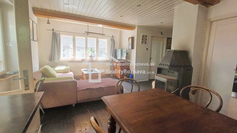 Living room of a family house with a wooden table and a fireplace, floor with wooden decor.