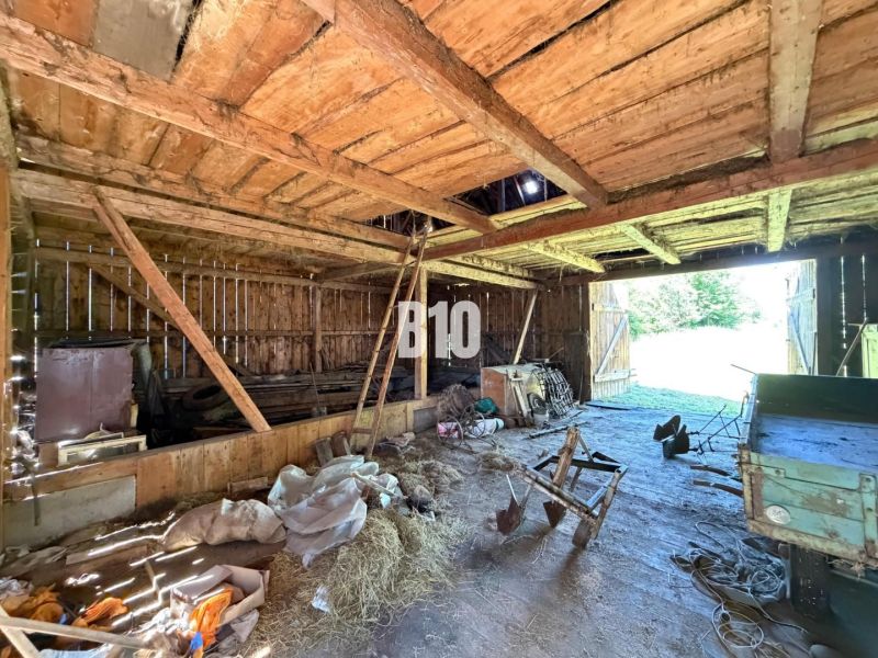 A wooden barn at the cottage in Dubové with tools and open doors.
