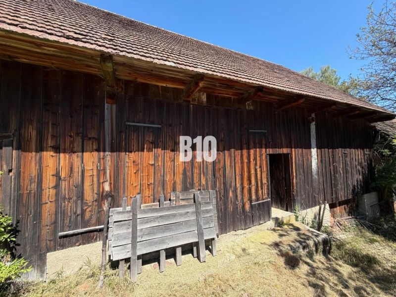 A wooden cottage in Dubové with a characteristic shingle roof against the backdrop of a blue sky.
