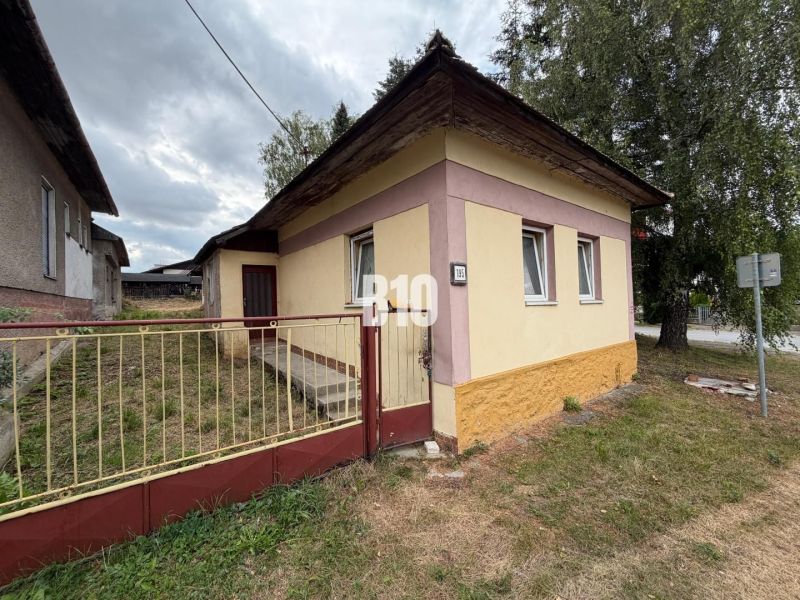 A family house in Mošovce with a colorful facade and a grass-covered plot.