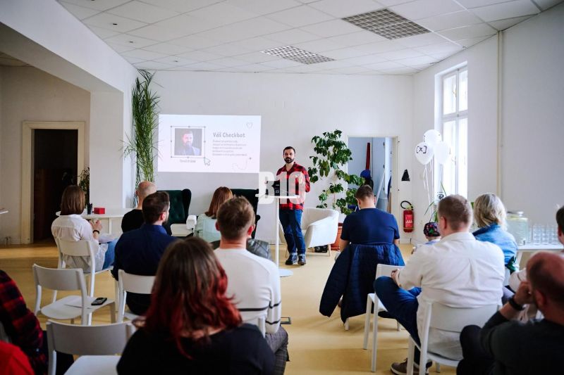 A lecture in the office, participants sitting on chairs, presentation projected on the wall.
