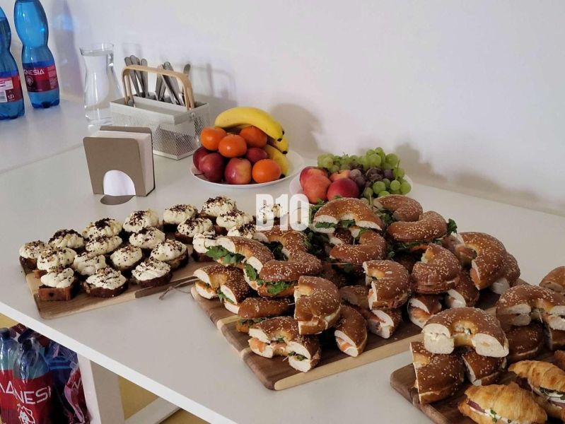 Snack bar in offices with refreshments, fruit, and water on a serving table.