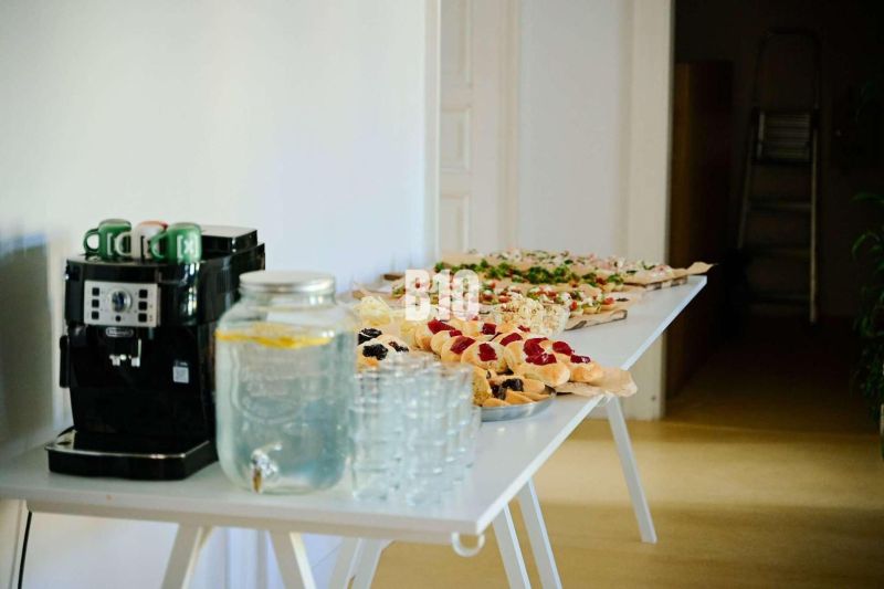 Office buffet with a coffee machine, a water pitcher, and snacks.