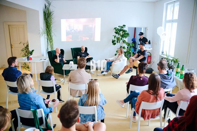 Discussion in the office with people sitting on chairs, with a projected image on the wall.