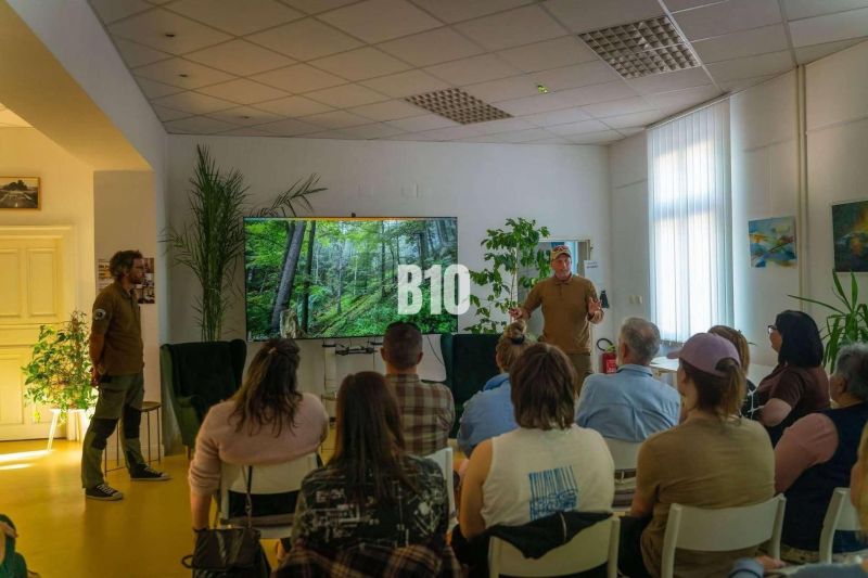 A group of people in an office with a nature projection on the screen.