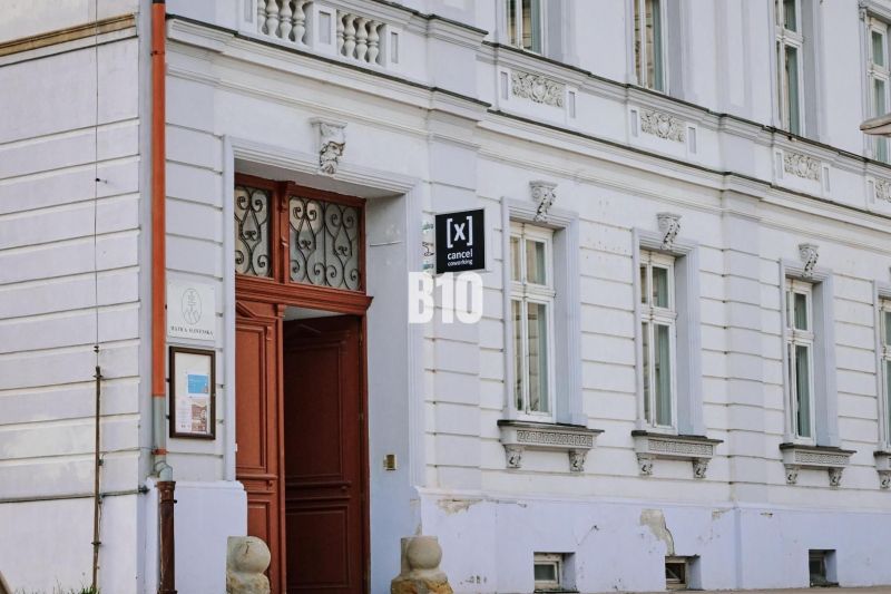 Entrance to the offices in Martin with a white facade and wooden doors.