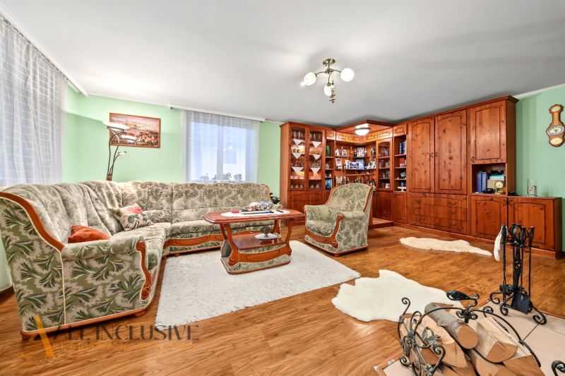 Living room in a family house with a wooden decor floor and a comfortable sofa.