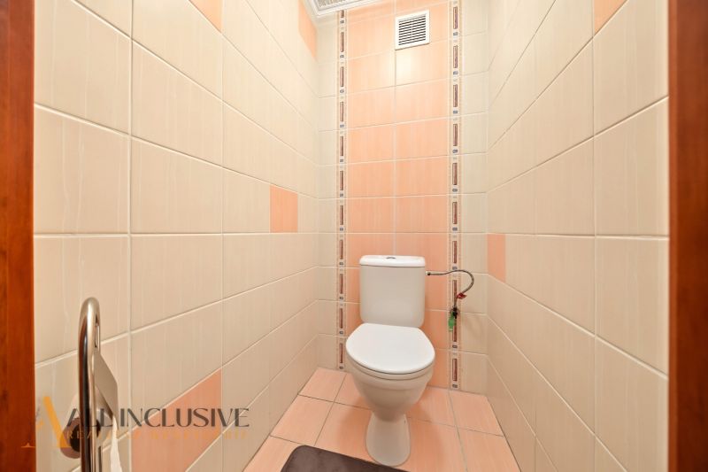 A bathroom with light tiles in a family house, simple design.