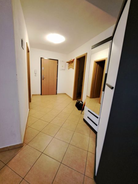 An entrance hall with tiles and a coat rack in a 2-room apartment.