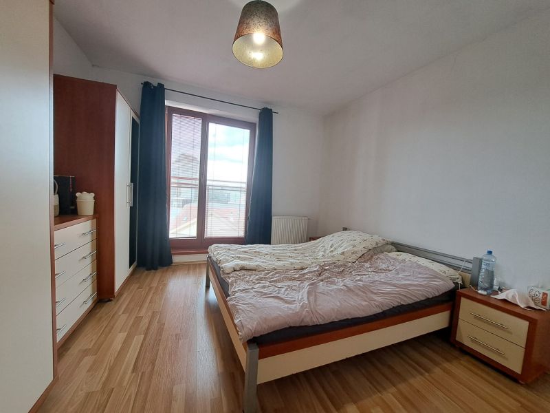 Bedroom in a 2-room apartment with a bed and a floor with a wooden decor.