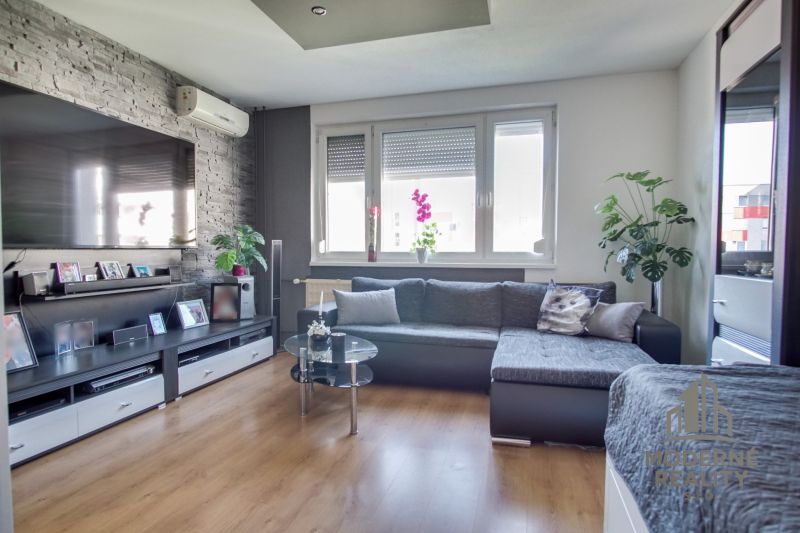 Living room in a 3-room apartment with a wooden decor floor and comfortable seating.