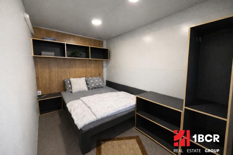 Bedroom in a holiday apartment with a bed and a shelving unit on the wall.