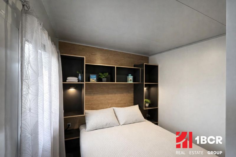 Bedroom in a holiday apartment with a bed, shelves, and details in wooden decor.