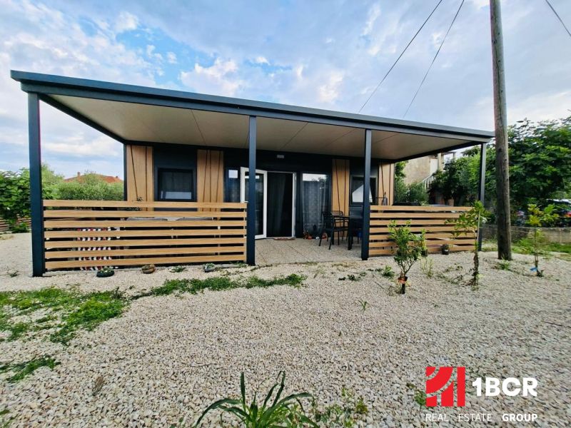 Recreational apartment in Sukošan with a terrace, garden seating, and gravel paving.