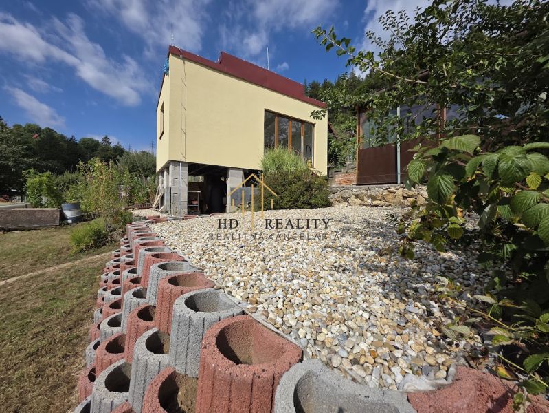 A cottage on Tulská Street in Banská Bystrica with an elevated garden and stone landscaping.