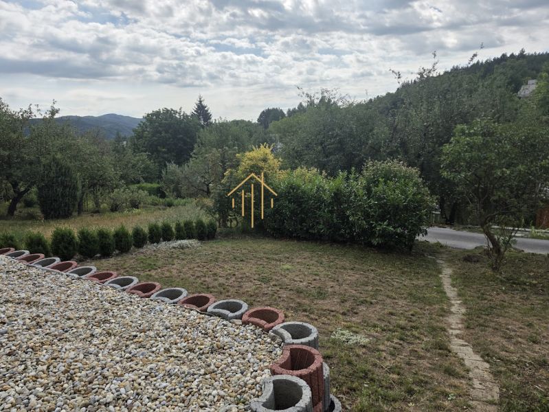 The garden at the cottage on Tulská Street in Banská Bystrica, surrounded by trees and flowers.