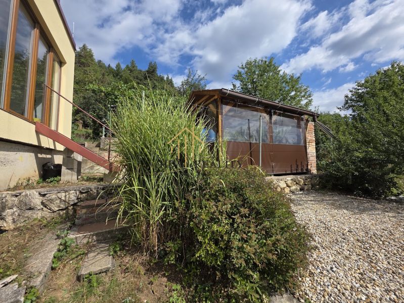 The house on Tulská Street in Banská Bystrica, surrounded by greenery and a stone path.