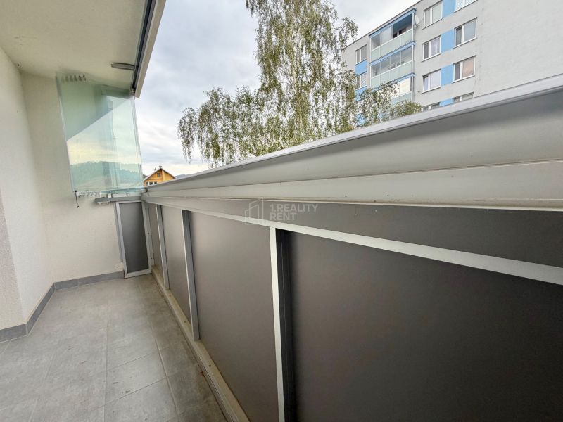 A balcony with tiles, railing, and a view of a building in Krásno nad Kysucou, Struhy, 3-room apartment.