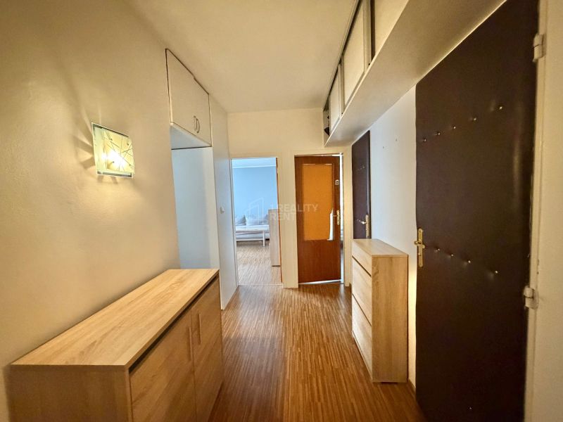 A hallway with storage space and a wooden decor floor in a 3-room apartment.