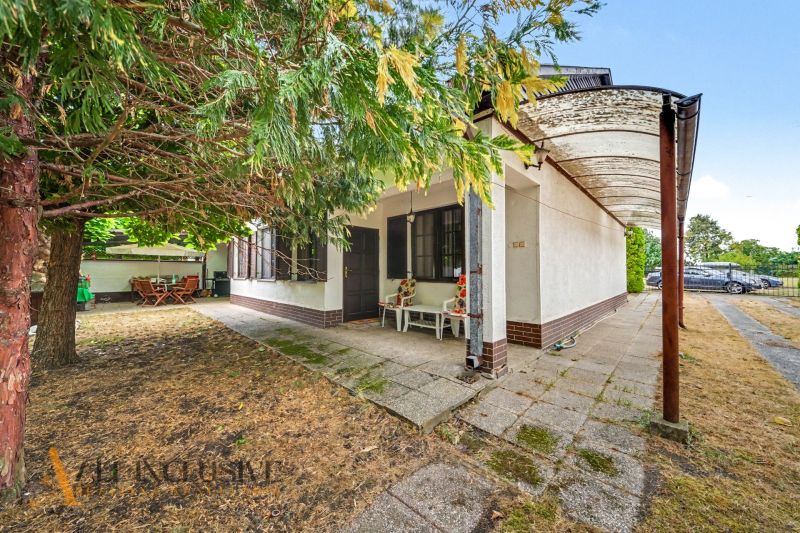 A family house in Lipové with a terrace, a column, and dining under the trees in the garden.