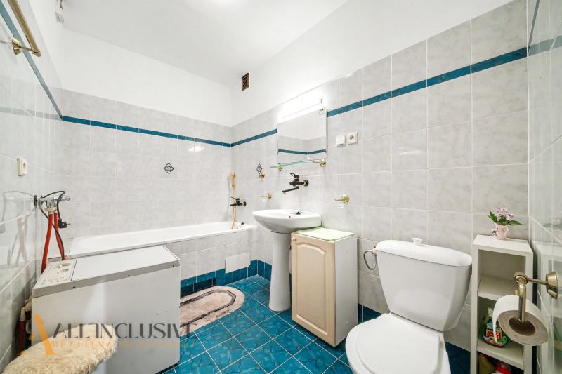 A bathroom in a family house with white tiles and a blue floor.