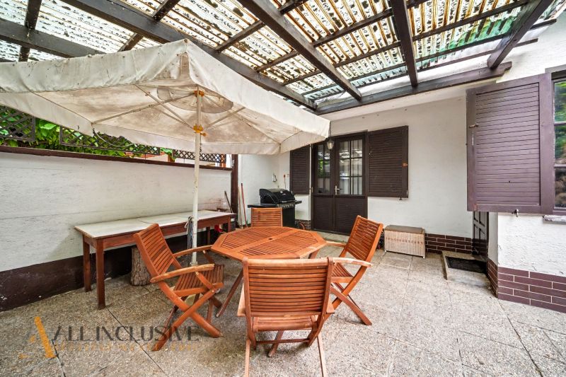 The terrace of a family house in Lipov with wooden garden furniture and a large umbrella.