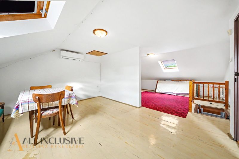 Attic interior of a family house, light wooden decor flooring, dining table.