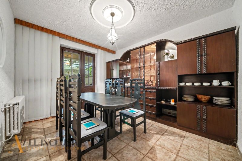 Dining room with wooden furniture and decorative elements in a family house.