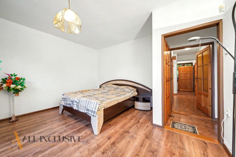A bedroom in a family house with a bed and a wooden decor floor.
